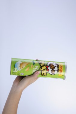 bir tüp patates cipsi tutan el