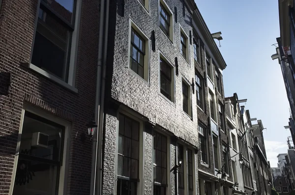 Holland, Amsterdam; the facade of old stone houses in a central street of the city - EDITORIAL — Stock Photo, Image