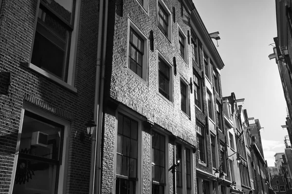 Holanda, Amsterdam; la fachada de antiguas casas de piedra en una calle central de la ciudad - EDITORIAL —  Fotos de Stock