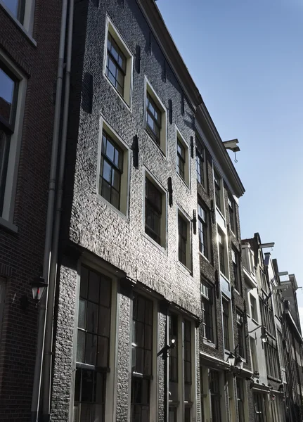 Olanda, Amsterdam; la facciata di vecchie case in pietra in una strada centrale della città - EDITORIALE — Foto Stock