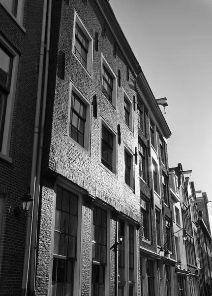 Holland, Amsterdam; the facade of old stone houses in a central street of the city - EDITORIAL — Stock Photo, Image