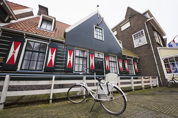 Holland, Volendam (Amsterdã); 9 de outubro de 2011, uma bicicleta estacionada em frente a uma antiga casa de pedra - EDITORIAL — Fotografia de Stock