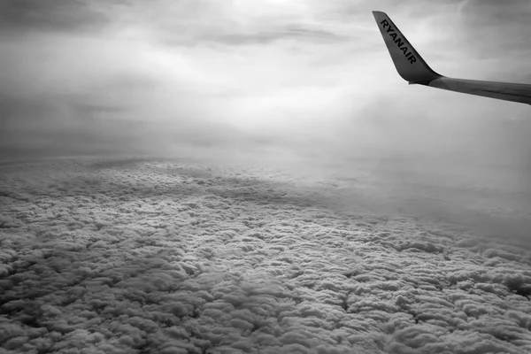 Італія; 5 березня 2016 року літак, що летить над хмарами - редакції — стокове фото
