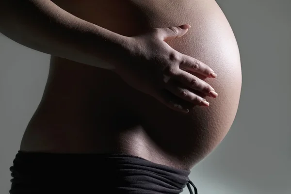 Studio portret van een zwangere vrouw Stockfoto