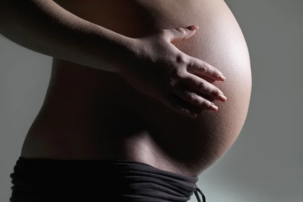 Studio ritratto di una donna incinta Foto Stock