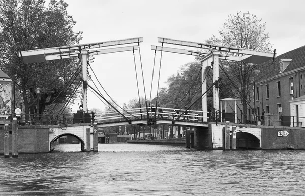 Holland, amsterdam; 10. Oktober 2011, Menschen überqueren eine Hubbrücke auf einem Wasserkanal - Leitartikel — Stockfoto