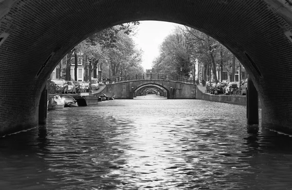 Holland, Amsterdam, gamla stenbroar vatten kanal — Stockfoto