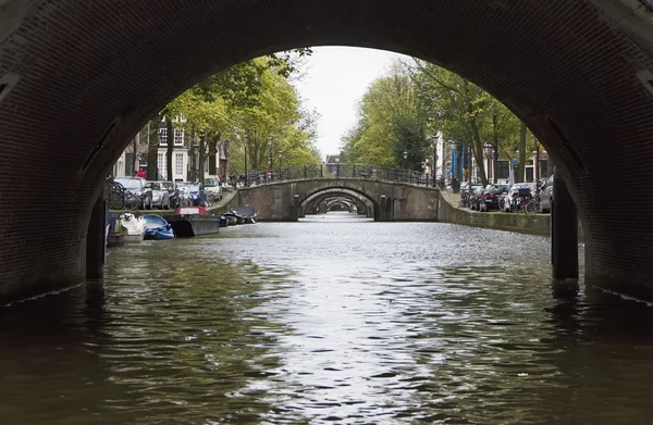 Holland, Amsterdam, gamla stenbroar vatten kanal — Stockfoto