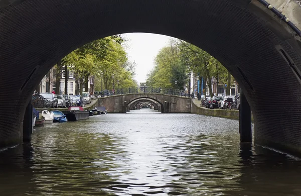 Holland, Amsterdam, gamla stenbroar vatten kanal — Stockfoto