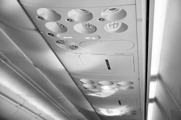 Italy, airplane cabin with the fasten belts and no smoking signs on — Stock Photo, Image