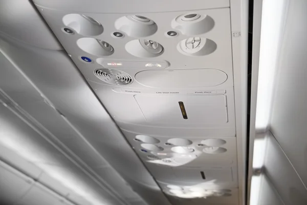 Italia, cabina del avión con los cinturones abrochados y señales de no fumar en —  Fotos de Stock