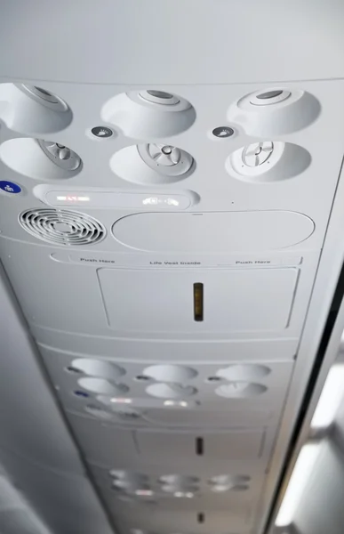 Italy, airplane cabin with the fasten belts and no smoking signs on — Stock Photo, Image