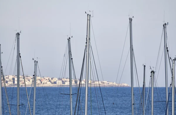 Italia, Sicilia, Mar Mediterráneo, Marina di Ragusa, mástiles de velero en el puerto deportivo y la costa siciliana en el fondo —  Fotos de Stock