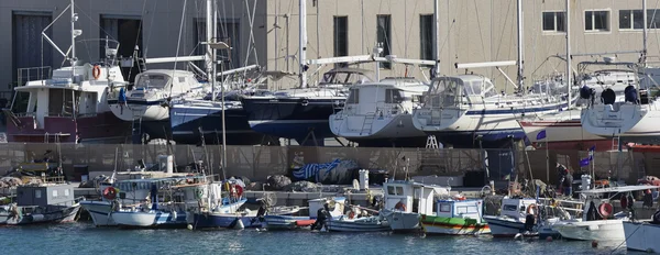 Italien, Sizilien, Mittelmeer, Marina di ragusa; 18. März 2016, hölzerne Fischerboote und Luxusyachten an Land in einer Bootswerft in der Marina - Leitartikel — Stockfoto