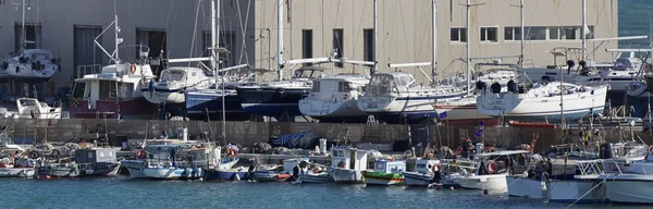 Italia, Sicilia, Mar Mediterráneo, Marina di Ragusa; 18 de marzo de 2016, barcos de pesca de madera y yates de lujo en tierra en un astillero en el puerto deportivo - EDITORIAL — Foto de Stock