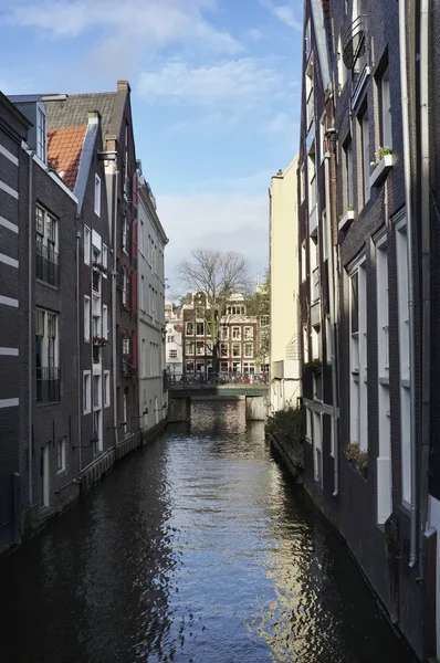 Holanda, Ámsterdam, antiguas casas de piedra en un canal de agua — Foto de Stock