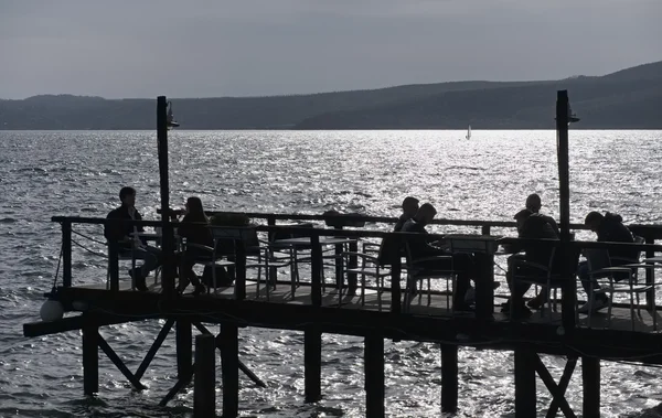 Italy, Lazio, Bracciano lake, Trevignano (Rome); 31 March 2016, people relaxing on a wooden pier by the lake - EDITORIAL — Stock Photo, Image