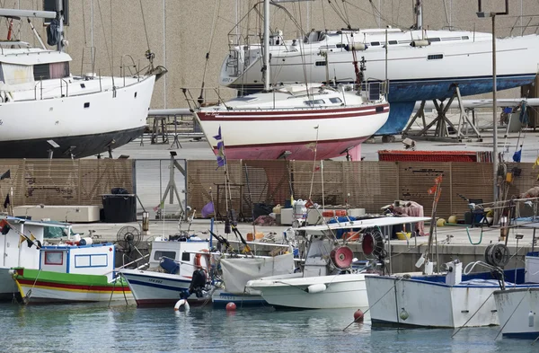 Италия, Сицилия, Средиземное море, Marina di Ragusa; 1 мая 2016, деревянные рыболовные лодки и роскошные яхты на берегу в гавани - РЕДАКЦИЯ — стоковое фото