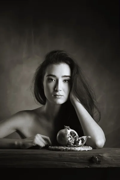 Studio portrait of a nude beautiful girl with a pomegranate — Stock Photo, Image