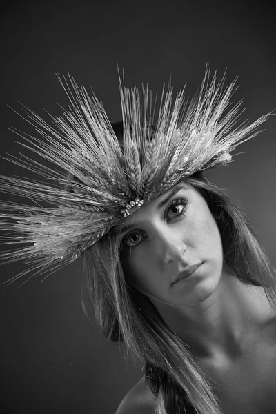 Studio portret van een mooi meisje met een kroon gemaakt met sheafs van tarwe — Stockfoto