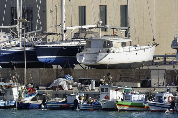 Italia, Sicilia, Mar Mediterraneo, Marina di Ragusa; 3 maggio 2016, barche da pesca in legno e yacht di lusso a terra nel porto - EDITORIALE — Foto Stock
