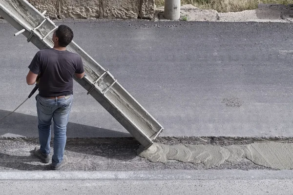 Italia, Sicilia; 12 de mayo de 2016, el hombre en el trabajo la fijación de una carretera - EDITORIAL — Foto de Stock