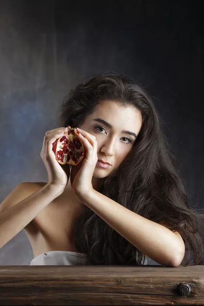 Italy, studio portrait of a beautiful girl with a pomegranate — Stock Photo, Image