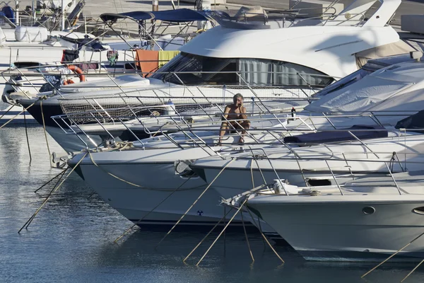 Италия, Сицилия, Средиземное море, Марина ди Рагуза; мужчина разговаривает по телефону на своей роскошной яхте в порту — стоковое фото