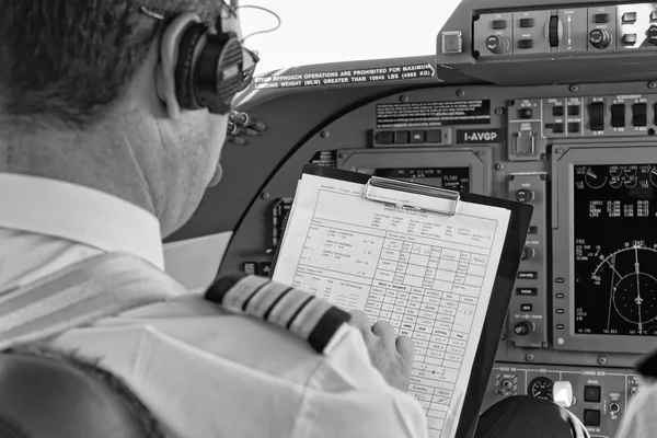 Italy, pilot checking his flight plan in an airplane's cockpit — Stock Photo, Image