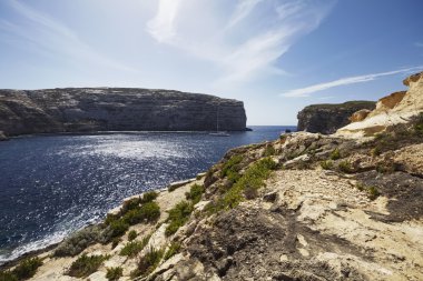 Malta Adası, Gozo, yelkenli tekne Dweira lagün ve kayalık sahil şeridi görünümünü Azure pencere Rock yakınındaki