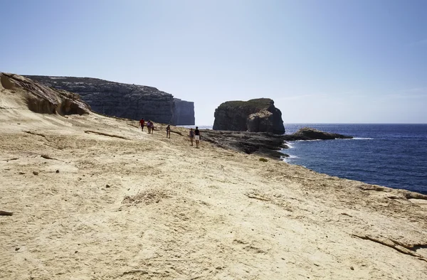 Ostrov Malta, Gozo, Dweira, lidí, kteří jdou na skalnaté pobřeží poblíž Azure Window Rock — Stock fotografie