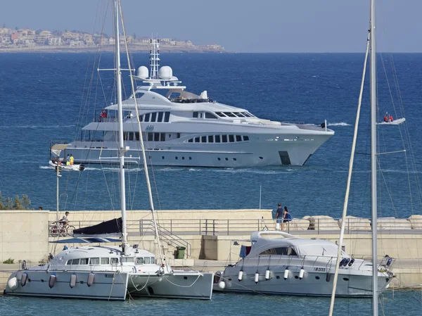 Italien, Sizilien, Mittelmeer, Marina di ragusa; 10. August 2016, Luxusyachten im Hafen und eine große im offenen Meer - Leitartikel — Stockfoto