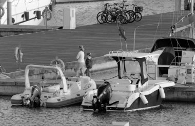 İtalya, Sicilya, Akdeniz, Marina di Ragusa (Ragusa Eyaleti); 24 Ekim 2020, limandaki insanlar, motorlu tekneler ve lüks yatlar - EDITORIAL