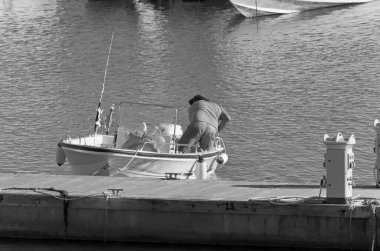 İtalya, Sicilya, Akdeniz, Marina di Ragusa (Ragusa ili); 31 Ekim 2020, limandaki bir motorlu teknede balıkçı - EDITORIAL