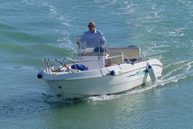 İtalya, Sicilya, Akdeniz, Marina di Ragusa (Ragusa Eyaleti); 31 Ekim 2020, limandaki bir motorlu teknede adam - EDITORIAL