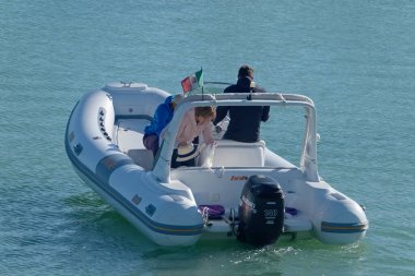 İtalya, Sicilya, Akdeniz, Marina di Ragusa (Ragusa Eyaleti); 1 Kasım 2020, limandaki kauçuk bir teknede insanlar - EDITORIAL