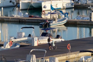 İtalya, Sicilya, Akdeniz, Marina di Ragusa (Ragusa Eyaleti); 14 Kasım 2020, limandaki insanlar, motorlu tekneler ve lüks yatlar - EDITORIAL