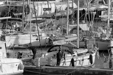 İtalya, Sicilya, Akdeniz, Marina di Ragusa (Ragusa Eyaleti); 26 Kasım 2020, limandaki insanlar ve yelkenliler - EDITORIAL