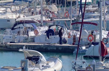 İtalya, Sicilya, Akdeniz, Marina di Ragusa (Ragusa Eyaleti); 5 Aralık 2020, limandaki insanlar ve lüks yatlar - EDITORIAL