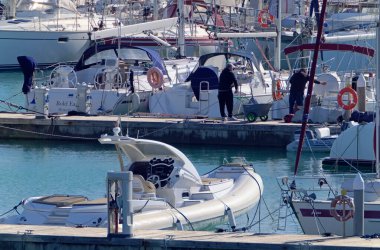 İtalya, Sicilya, Akdeniz, Marina di Ragusa (Ragusa Eyaleti); 5 Aralık 2020, limandaki insanlar ve lüks yatlar - EDITORIAL