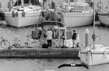 İtalya, Sicilya, Akdeniz, Marina di Ragusa (Ragusa Eyaleti); 6 Aralık 2020, limandaki insanlar ve yelkenliler - EDITORIAL