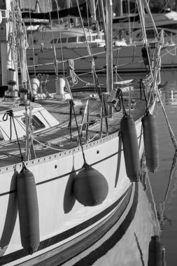 İtalya, Sicilya, Akdeniz, Marina di Ragusa (Ragusa Eyaleti); limandaki bir yelkenli teknesinde vinç ve deniz ipleri 