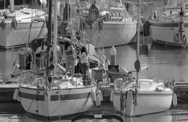 İtalya, Sicilya, Akdeniz, Marina di Ragusa (Ragusa Eyaleti); 6 Şubat 2021, limandaki bir yelkenli teknesinde insanlar - EDITORIAL