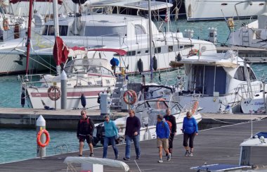 İtalya, Sicilya, Akdeniz, Marina di Ragusa (Ragusa Eyaleti); 11 Şubat 2021, limandaki insanlar ve lüks yatlar - EDITORIAL