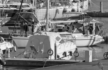 İtalya, Sicilya, Akdeniz, Marina di Ragusa (Ragusa Eyaleti); 16 Şubat 2021, limandaki bir yelkenli ve lüks yatlarda yaşayan insanlar - EDITORIAL