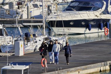 İtalya, Sicilya, Akdeniz, Marina di Ragusa (Ragusa Eyaleti); 16 Şubat 2021, limandaki insanlar ve lüks yatlar - EDITORIAL