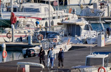 İtalya, Sicilya, Akdeniz, Marina di Ragusa (Ragusa Eyaleti); 16 Şubat 2021, limandaki insanlar ve lüks yatlar - EDITORIAL