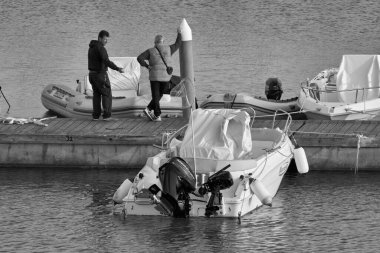 İtalya, Sicilya, Akdeniz, Marina di Ragusa (Ragusa Eyaleti); 26 Şubat 2021, limanda insanlar ve motorlu tekneler - EDITORIAL