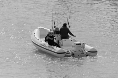 İtalya, Sicilya, Akdeniz, Marina di Ragusa (Ragusa Eyaleti); 1 Mart 2021, limandaki kauçuk teknede balıkçılar - EDITORIAL