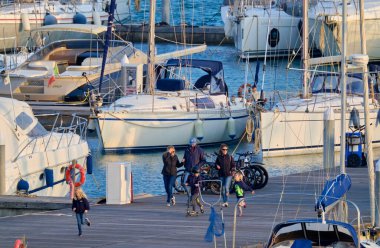 İtalya, Sicilya, Akdeniz, Marina di Ragusa (Ragusa Eyaleti); 1 Mart 2021, limandaki insanlar ve lüks yatlar - EDITORIAL